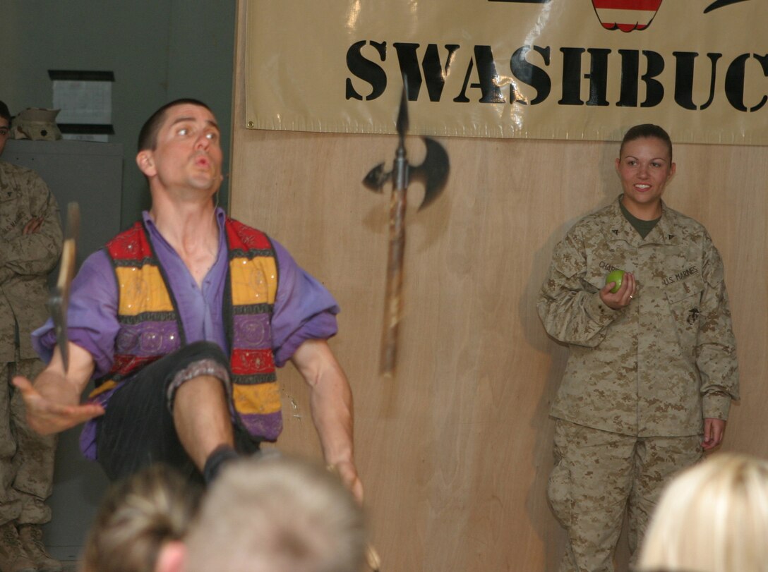 CAMP BLUE DIAMOND, AR RAMADI, Iraq - Lance Cpl. Holly Charette, a 21-year-old mail clerk from Cranston, R.I. watches as Juggler, comedian and award-winning motivational speaker, Dan Thurmon, juggles a hatchet, a battle ax and a machete during Operation Swashbuckle. Thurmon is a member of the four-man comedy show presented by Hack and Slash, who provided an explosive round of entertainment for more than 100 Marines, sailors and soldiers here serving with the 2nd Marine Division in support of Operation Iraqi Freedom.