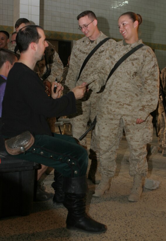CAMP BLUE DIAMOND, AR RAMADI, Iraq - Lance Cpl. Holly Charette, a 21-year-old mail clerk from Cranston, R.I. gets an autograph Shakespearean comic-sword fighter, "Slash" after a performance during Operation Swashbuckle. Slash is a member of the four-man comedy show presented by Hack and Slash, who provided an explosive round of entertainment for more than 100 Marines, sailors and soldiers here serving with the 2nd Marine Division in support of Operation Iraqi Freedom.