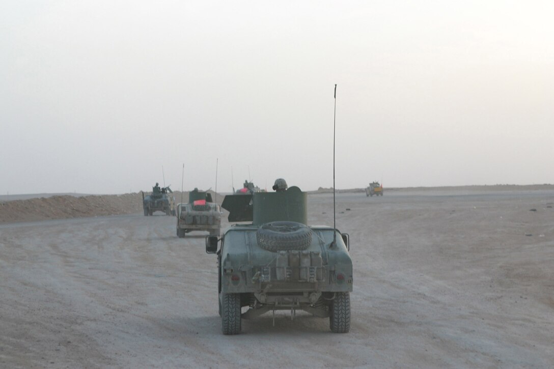 CAMP KOREAN VILLAGE, Iraq -- Marines of 2nd Military Police Battalion, 4th Tank Battalion, roll out in their High Mobility Multi-Wheeled Vehicles during a convoy, March 26.  The reservists are from Kansas City, Mo.  U.S. Marine Corps photo by Sgt. Stephen D'Alessio (RELEASED)