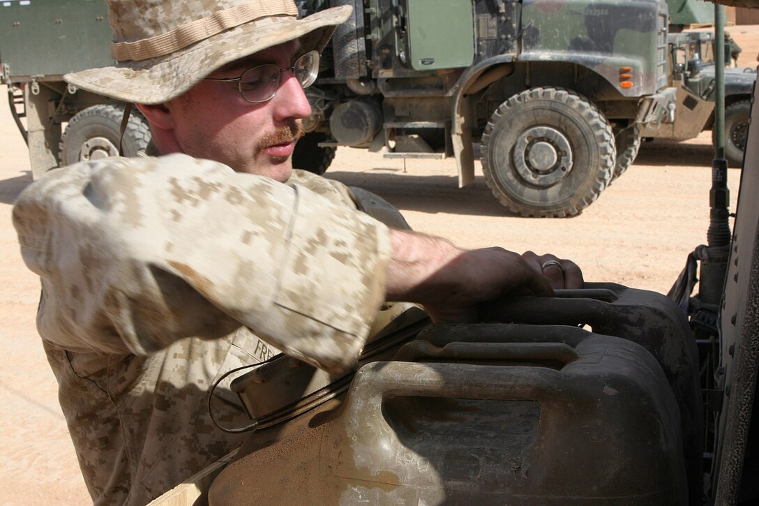 CAMP KOREAN VILLAGE, Iraq -- Lance Corporal Damion Freeman, a 23-year-old Kansas City, Mo. native and military policeman with 2nd Military Police Battalion, 4th Tank Battalion, gets fuel for his High Mobility Multi-Wheeled Vehicle before a convoy, March 26.  Freeman is a 1999 Shawnee Mission Northwest High School graduate and reservist. U.S. Marine Corps photo by Sgt. Stephen D'Alessio (RELEASED)