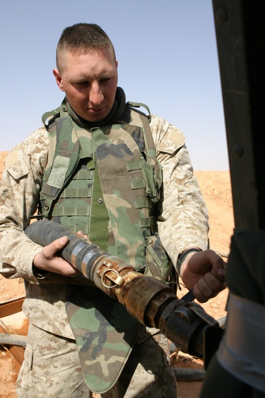 CAMP KOREAN VILLAGE, Iraq -- Sergeant Joseph Schmidt, a 28-year-old Kansas City, Mo. native and military policeman with 2nd Military Police Battalion, 4th Tank Battalion, refuels his High Mobility Multi-Wheeled Vehicle before a convoy, March 26.  Rodriguez is a 1994 Oswego High School graduate and reservist from Kansas City, Mo. U.S. Marine Corps photo by Sgt. Stephen D'Alessio (RELEASED)