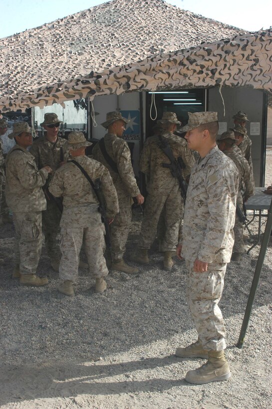 CAMP HURRICANE POINT, Ar Ramadi, Iraq (April 21, 2005) -Sergeant Miguel E. Mejia, retail store manager with Headquarters and Service Company, 2nd Force Service Support Group, 2nd Marine Division, watches Marines lined up outside the post exchange here. The 24-year-old Salinas, Puerto Rico native, runs the Warfighter Express Service Team, which provides exchange items for purchase, dispersing and postal services to warriors fighting on the frontlines of the urban battlefield. Each week, Mejia loads a 7-ton truck full of merchandise from the Camp Ramadi Exchange and visits Camps Snake Pit and HP where Marines with 1st Battalion, 5th Marines reside. Photo by Cpl. Tom Sloan