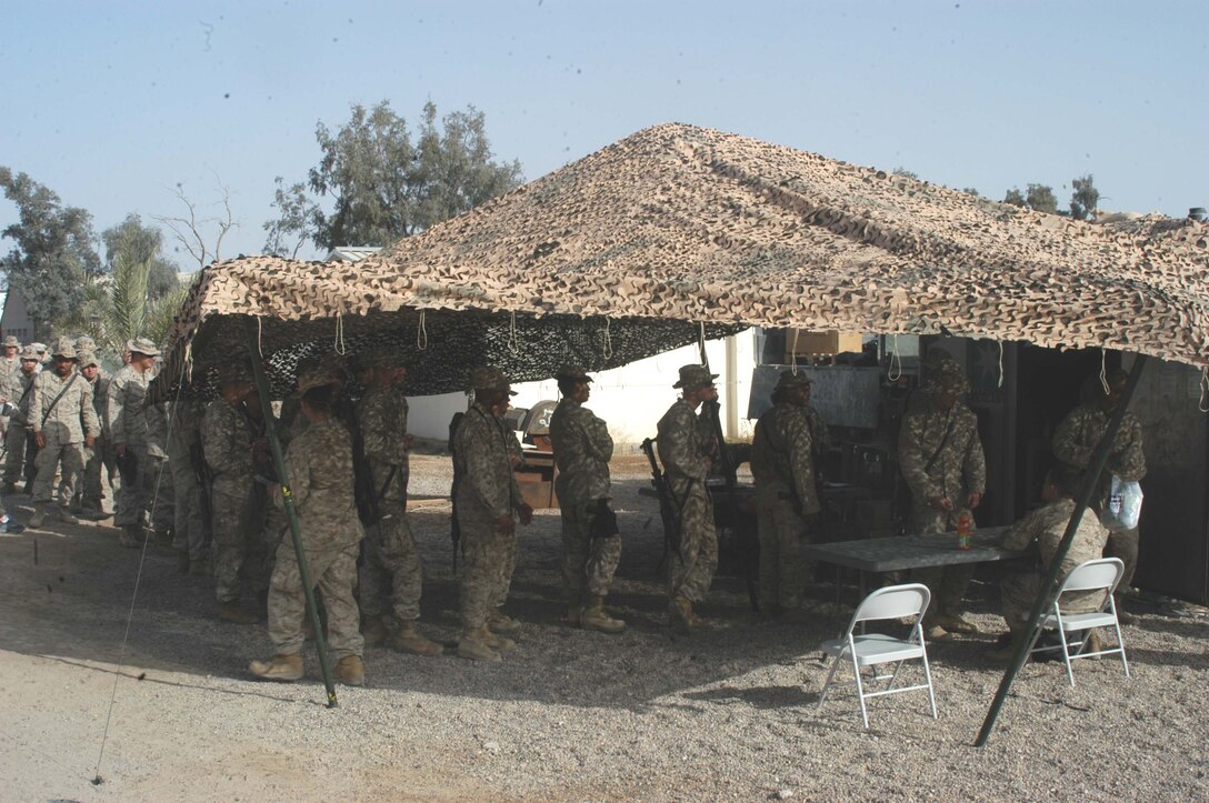 CAMP HURRICANE POINT, Ar Ramadi, Iraq (April 21, 2005) -Marines with 1st Battalion, 5th Marine Regiment, wait in line outside the post exchange during its weekly visit to their base here. The PX is provided by the Warfighter Express Service Team, which provides exchange items for purchase, dispersing and postal services to warriors fighting on the frontlines of the urban battlefield. The PX is also offered to leathernecks with 1st Battalion, 5th Marines living at Camp Snake Pit. Photo by Cpl. Tom Sloan