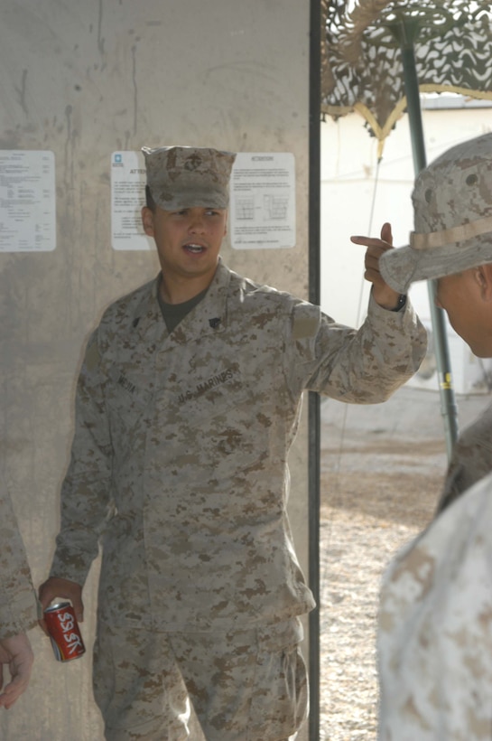 CAMP HURRICANE POINT, Ar Ramadi, Iraq (April 21, 2005) -Sergeant Miguel E. Mejia, retail store manager with Headquarters and Service Company, 2nd Force Service Support Group, 2nd Marine Division, ushers Marines into the post exchange here. The 24-year-old Salinas, Puerto Rico native, runs the Warfighter Express Service Team, which provides exchange items for purchase, dispersing and postal services to warriors fighting on the frontlines of the urban battlefield. Each week, Mejia loads a 7-ton truck full of merchandise from the Camp Ramadi Exchange and visits Camps Snake Pit and HP where Marines with 1st Battalion, 5th Marines reside. Photo by Cpl. Tom Sloan