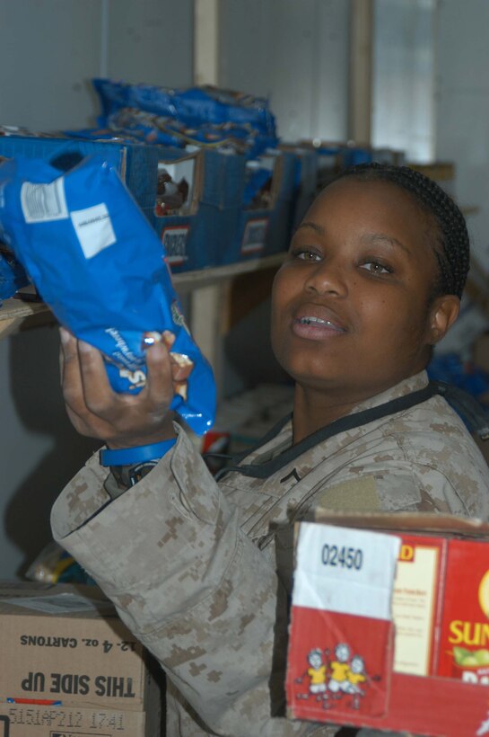 CAMP HURRICANE POINT, Ar Ramadi, Iraq (April 21, 2005) - Private First Class Melissa D. Clark, a 24-year-old disperser with Headquarters and Service Company, 2nd Force Service Support Group, 2nd Marine Division, and Queens, N.Y., native, stack a shelf in the post exchange here with merchandise. The PX is provided by the Warfighter Express Service Team, which provides exchange items for purchase, dispersing and postal services to warriors fighting on the frontlines of the urban battlefield. The PX is also offered to leathernecks with 1st Battalion, 5th Marines living at Camp Snake Pit. Photo by Cpl. Tom Sloan