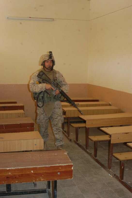 AR RAMADI, Iraq (May 26, 2005) - Sergeant Charles F. Crellin, a rifleman and the training noncommissioned officer for Company C, 1st Battalion, 5th Marine Regiment, walks through an empty class room at the Al Jaod Elementary School here during a civil affairs mission with 4th Platoon, Company C and Marines with Team 1, Detachment 3, 5th Civil Affairs Group, which is direct support of the infantry battalion. The 28-year-old from Cincinnati and his fellow Marines surveyed the school and determined what repairs and supplies are needed. Photo by: Cpl. Tom Sloan
