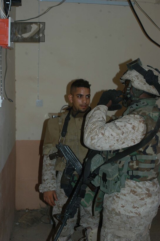 AR RAMADI, Iraq (May 26, 2005) - Gunnery Sgt. Wayne B. McClam, (right) the team chief for Team 1, Detachment 3, 5th Civil Affairs Group, which is in direct support of 1st Battalion, 5th Marine Regiment, and his translator view a broken fire alarm at the Al Jaod Elementary School here during a civil affairs mission with 4th Platoon, Company C. The Marines surveyed the school and determined what repairs and supplies are needed. Photo by: Cpl. Tom Sloan