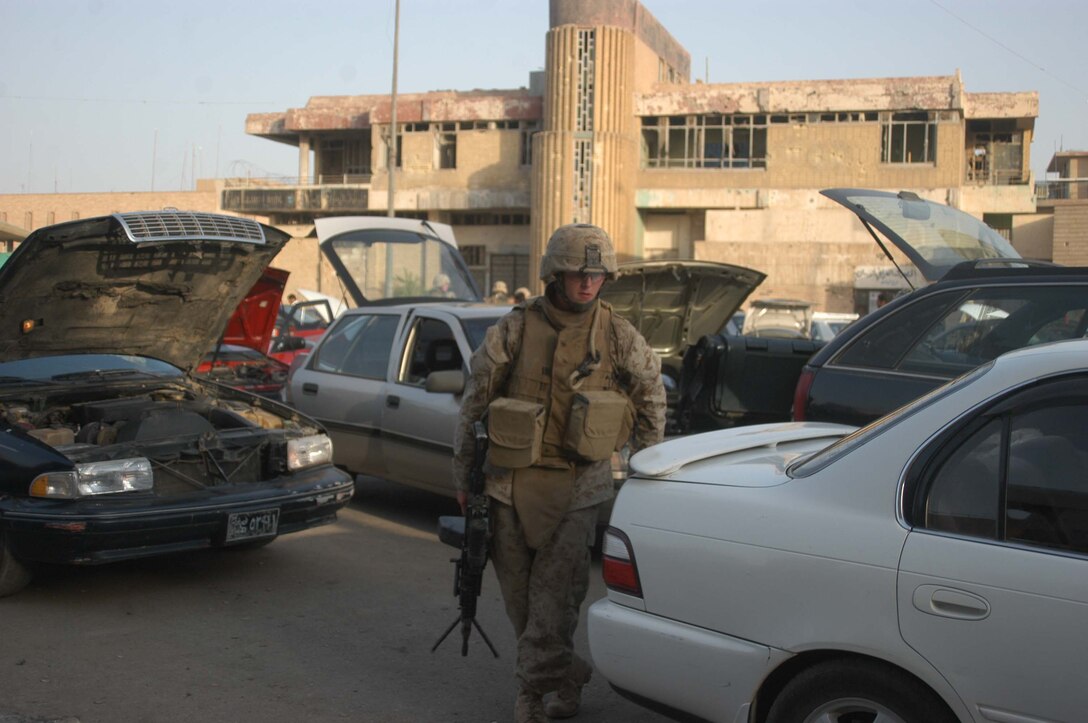 AR RAMADI Iraq (July 25, 2005) - Lance Cpl. Michael S. Fisher, a squad automatic gunner with 1st Squad, 2nd Platoon, Company A, 1st Battalion, 5th Marine Regiment, searches vehicles during a mission in the city here July 25. Twenty-one-year-old Fisher from Minneapolis and fellow Marines with the Camp Pendleton, Calif., -based infantry battalion conducted a battalion-wide operation in the city's marketplace, where they searched vehicles and personnel for weapons and improvised explosive making material. Photo by: Cpl. Tom Sloan