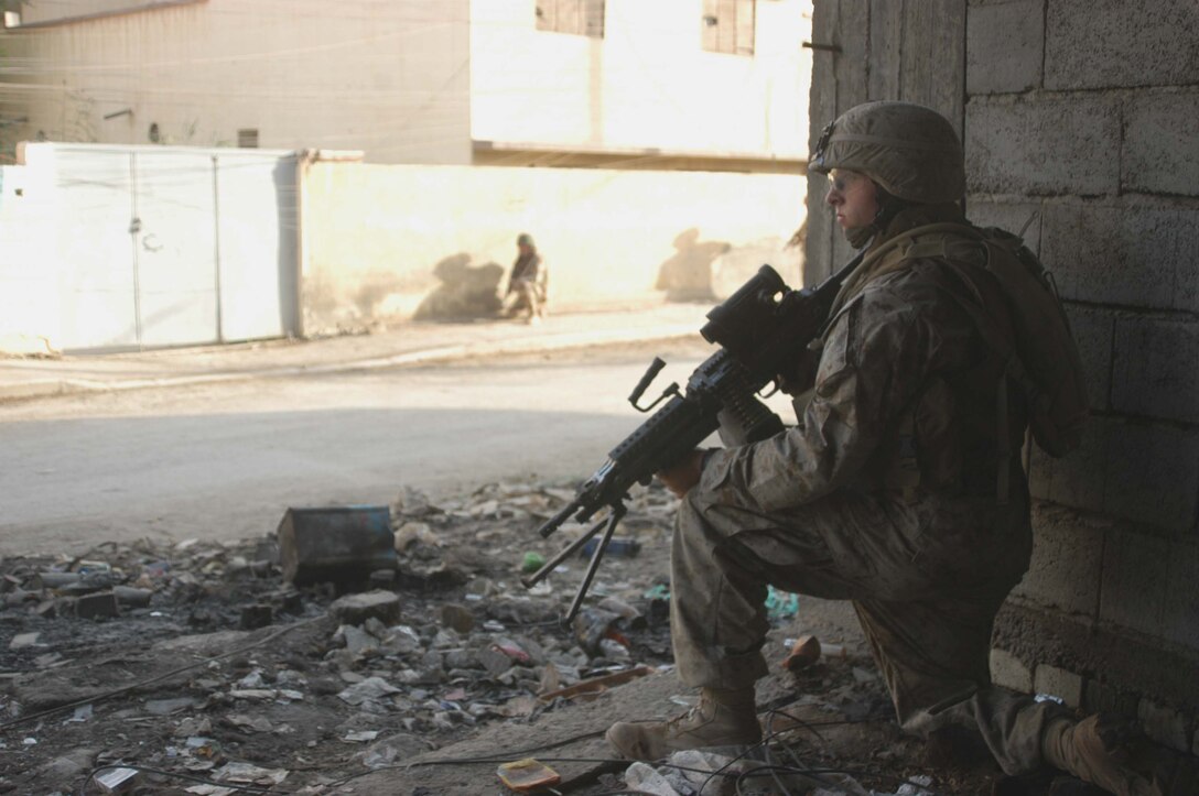 AR RAMADI Iraq (July 25, 2005) - Lance Cpl. Michael S. Fisher, a squad automatic gunner with 1st Squad, 2nd Platoon, Company A, 1st Battalion, 5th Marine Regiment, takes a knee provides security from an abandoned building in the city here during a mission July 25. Twenty-one-year-old Fisher from Minneapolis and fellow Marines with the Camp Pendleton, Calif., -based infantry battalion conducted a battalion-wide operation in the city's marketplace, where they searched vehicles and personnel for weapons and improvised explosive making material. Photo by: Cpl. Tom Sloan