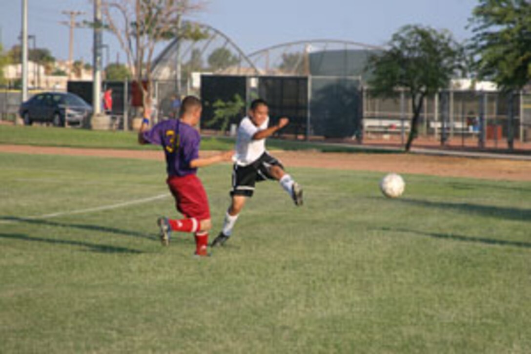 Jonathan Colobong of HQBN 2 kicks the ball out of bounds to stop short an attempt by MCCES? Hector Deltorofranco Tuesday night at Felix Field.  HQBN 2 won 2-1.
