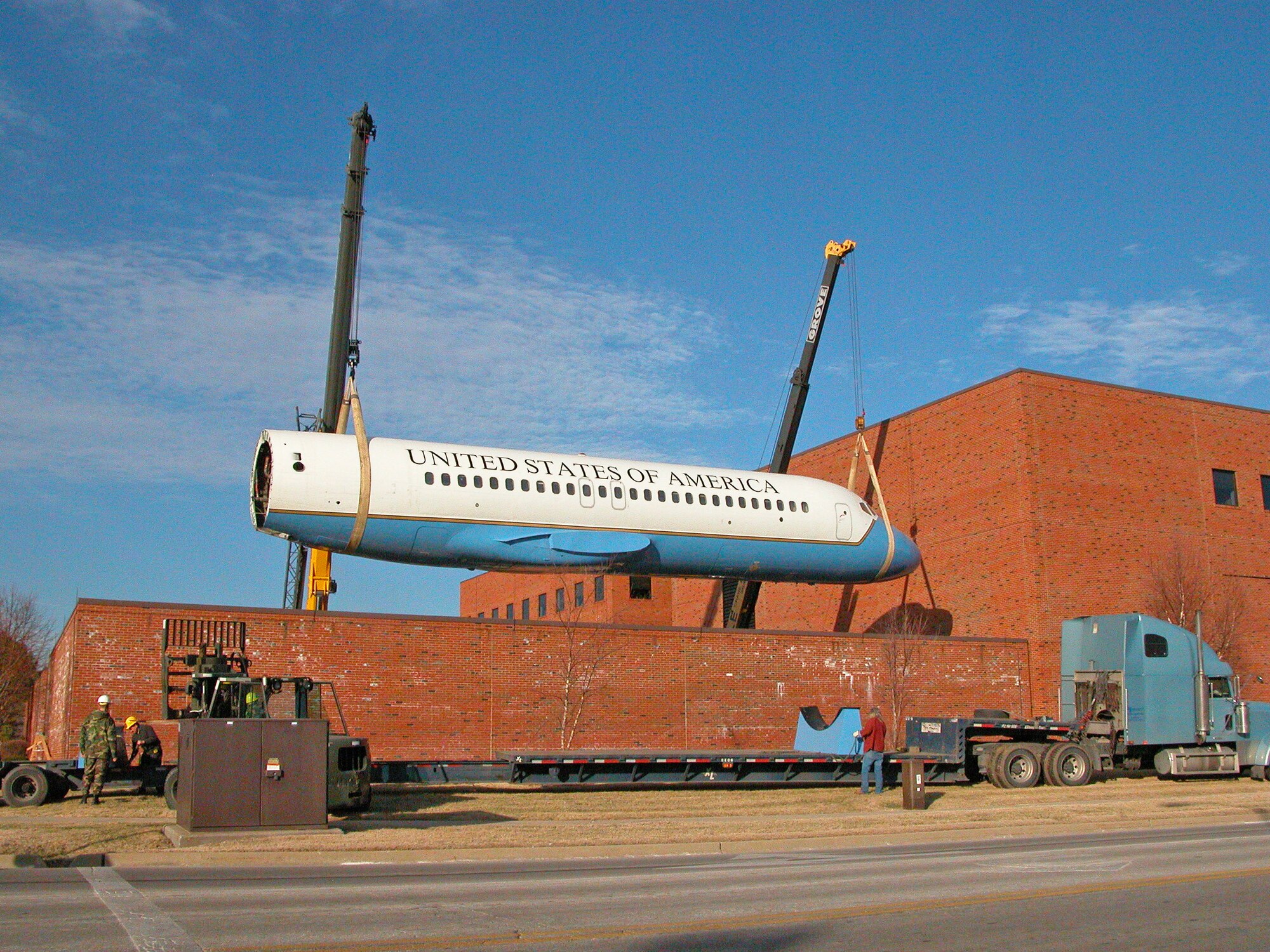 SCOTT AIR FORCE BASE, Ill. -- A DC-9 fuselage is suspended while people begin removing the stands from the truck to place them inside an Air Force Communications Agency compound where the fuselage will rest.  (U.S. Air Force photo by Gerald Sonnenberg)
