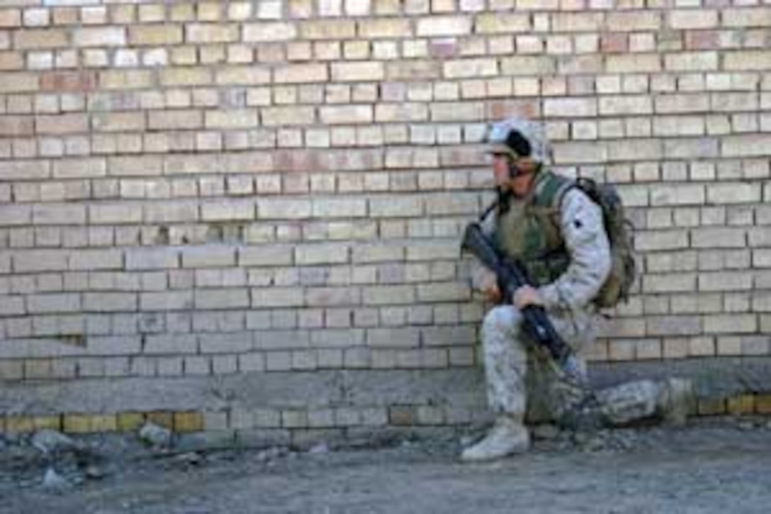 Co., Battalion Landing Team 1/1, and a native of Puxico, Mo., takes a knee while providing security during a patrol here. BLT 1/1, attached to the 15th Marine Expeditionary Unit (Special Operations Capable), is currently conducting security and stabilization operations in the Greater Baghdad area.