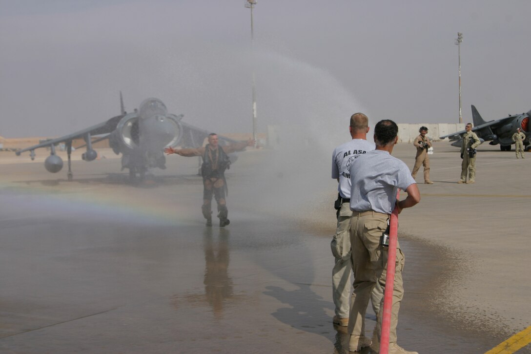 Colonel Clyde Woltman, former commanding officer, Marine Attack Squadron 311 gets ceremoniously drenched witha fire hose after his final flight as the Tomcats commanding officer.