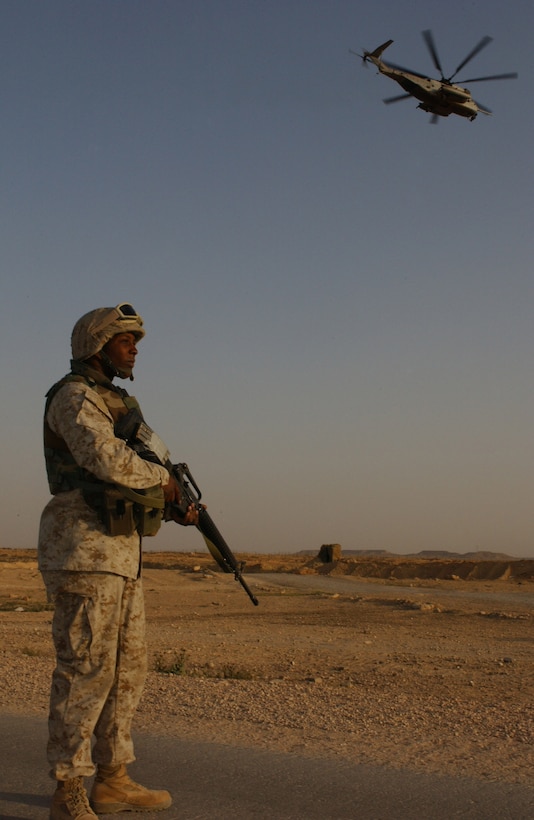 Lance Cpl. Lorenzo Oliver provides security as a departing CH-53E Super Stallion leaves forward arming refueling point, Al Qaim, Iraq.  Oliver and three other Marines or part of the provisional rifle platoon for Marine Wing Support Squadron 271, 2nd Marine Aircraft Wing, from Cherry Point, N.C.  They support the daily arrival and departure of rotor wing aircraft as Operation Iraqi Freedom and the Global War on Terrorism continues.
