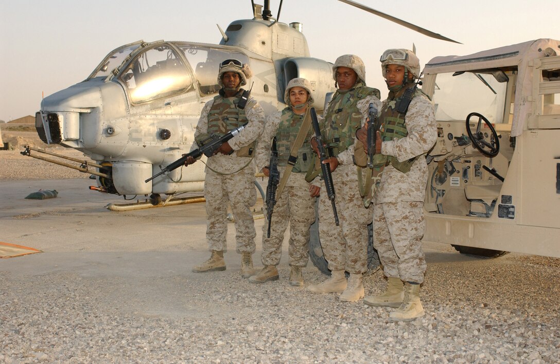 Left to Right:  Lance Corporals Lorenzo Oliver, Julian A. Valazquez, Andre Booker, and Cpl. Maurice Mincey stand before a AH-1W Super Cobra, one of the aircraft they protect at the forward arming refueling point, Al Qaim, Iraq, near the Syrian border.  These Marines or part of the provisional rifle platoon for Marine Wing Support Squadron 271, 2nd Marine Aircraft Wing, from Cherry Point, N.C.  They support the daily arrival of rotor wing aircraft as Operation Iraqi Freedom and the Global War on Terrorism continues.