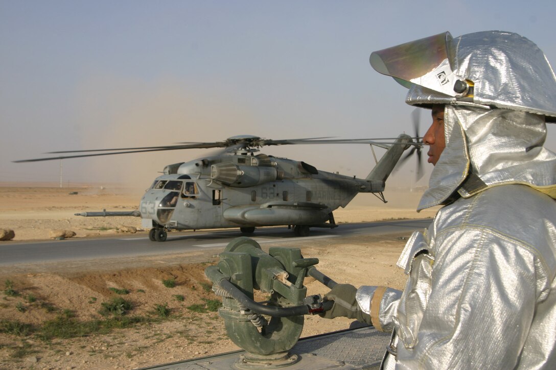 Corporal Gregory Hollins, rescueman, Aircraft, Rescue and Firefighting watches closely as a CH-53 Super Stallion lands aboard forward armed refueling point Al Qaim, Iraq, March 27. Hollins is one of four crash crewman who are responsible for all aircraft and structural fire defense in Al Qaim.