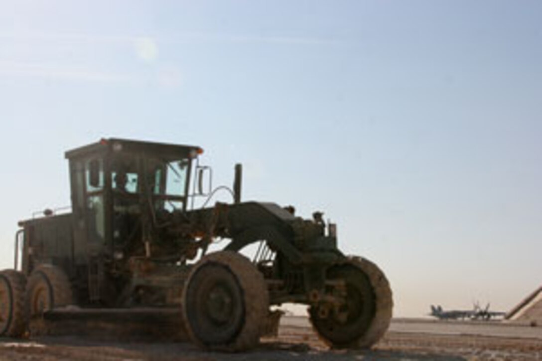 Sergeant Christopher Lewis, a heavy equipment operator with Marine Wing Support Squadron 272, drives a grader over a surface that will become the site of one of Al Asad, Iraq?s new marshalling pads.  The grader ensures a level surface which is necessary for a functional marshalling pad.