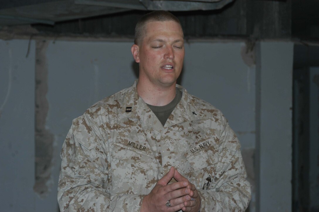 AR RAMADI, Iraq (March 27, 2005) - Navy Lt. Aaron T. Miller, chaplain for 1st Battalion, 5th Marine Regiment, prays while conducting Easter service at observation post VA here. The 32-year-old man of God from Redlands, Calif., visited Marines from the infantry battalion's five companies of whom he preached a hasty Easter service and served Holy Communion to. The effort, which lasted more than six hours, required Miller to travel to seven different places in the city where Marines are serving. Photo by Cpl. Tom Sloan