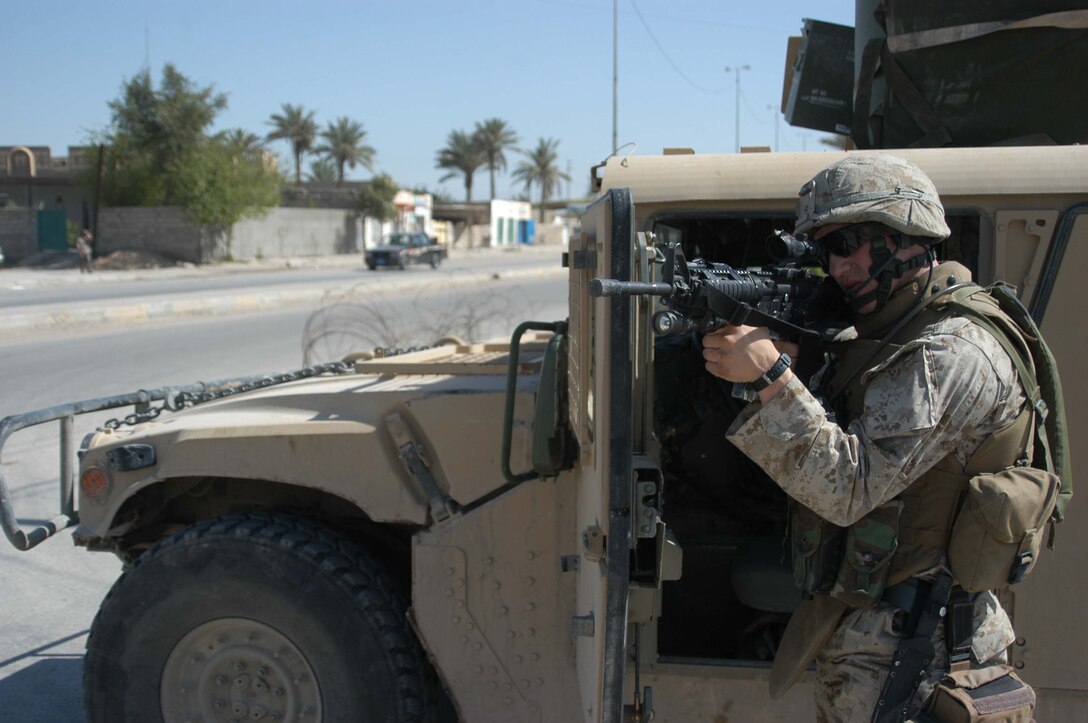 AR RAMADI, Iraq (March 27, 2005) - Looking down the end of his weapon, 21-year-old Cpl. David R. Pray of Gladstone, Mich., a rifleman with 1st Battalion, 5th Marine Regiment's commanding officer's security team, provides security while Navy Lt. Aaron T. Miller, chaplain for 1st Battalion, 5th Marine Regiment, makes his way to the humvee after conducting an Easter service to Marines at the observation post 295 here. The 32-year-old man of God from Redlands, Calif., visited Marines from the infantry battalion's five companies of whom he preached a hasty Easter service and served Holy Communion to. The effort, which lasted more than six hours, required Miller to travel to seven different places in the city where Marines are serving. Photo by Cpl. Tom Sloan