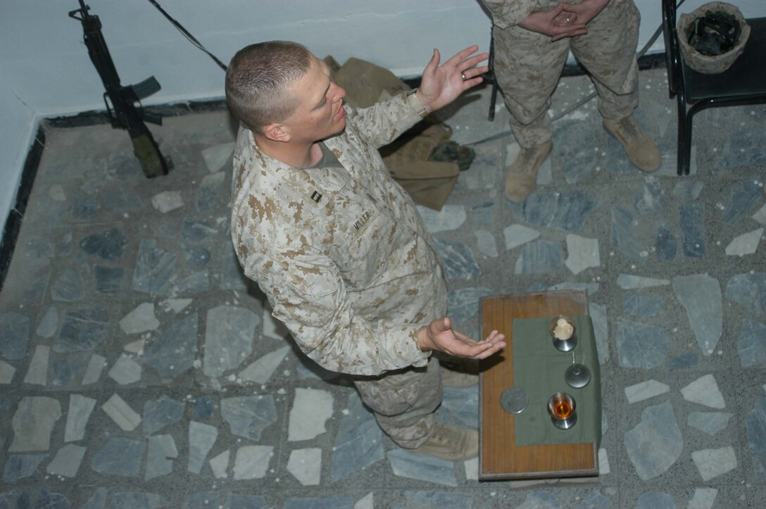 AR RAMADI, Iraq (March 27, 2005) - Navy Lt. Aaron T. Miller, chaplain for 1st Battalion, 5th Marine Regiment, prays while conducting Easter service inside the Government Center building here. The 32-year-old man of God from Redlands, Calif., visited Marines from the infantry battalion's five companies of whom he preached a hasty Easter service and served Holy Communion to. The effort, which lasted more than six hours, required Miller to travel to seven different places in the city where Marines are serving. Photo by Cpl. Tom Sloan