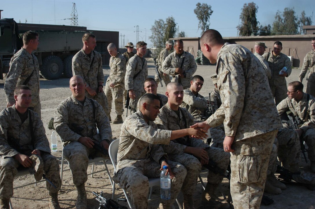 AR RAMADI, Iraq (March 27, 2005) - Navy Lt. Aaron T. Miller, chaplain for 1st Battalion, 5th Marine Regiment, shakes hands and wishes happy Easter to 20-year-old Lance Cpl. Jose R. Zuniga of Nordhein, Texas, and a rifleman squad automatic weapon gunner with 1st Squad, 1st Platoon, Company C, 1st Battalion, 5th Marine Regiment, during Easter service at Camp Snake Pit here. The 32-year-old man of God from Redlands, Calif., visited Marines from the infantry battalion's five companies of whom he preached a hasty Easter service and served Holy Communion to. The effort, which lasted more than six hours, required Miller to travel to seven different places in the city where Marines are serving. Photo by Cpl. Tom Sloan