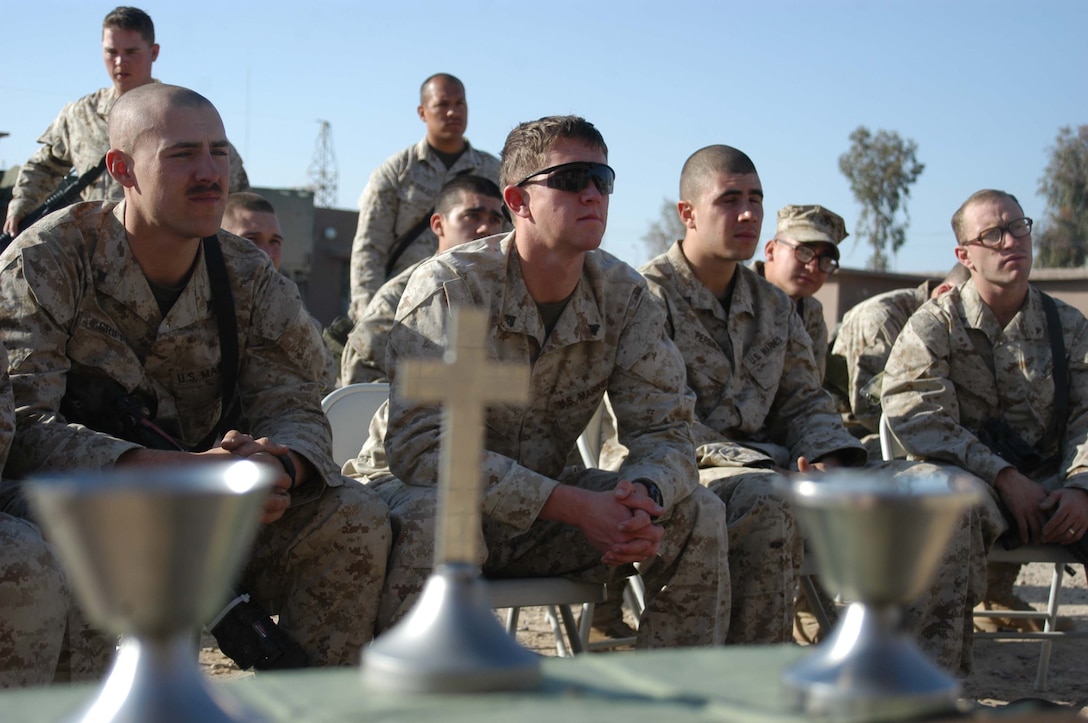 AR RAMADI, Iraq (March 27, 2005) - Marines with Company C, 1st Battalion, 5th Marine Regiment, listen attentively to Navy Lt. Aaron T. Miller, the infantry battalion's chaplain, conduct Easter service at Camp Snake Pit here. The 32-year-old man of God from Redlands, Calif., visited Marines from the infantry battalion's five companies of whom he preached a hasty Easter service and served Holy Communion to. The effort, which lasted more than six hours, required Miller to travel to seven different places in the city where Marines are serving. Photo by Cpl. Tom Sloan
