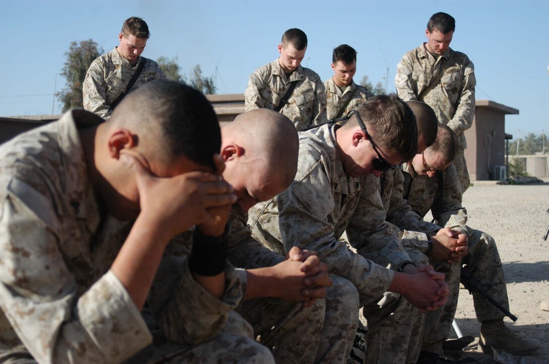 AR RAMADI, Iraq (March 27, 2005) - Marines with Company C, 1st Battalion, 5th Marine Regiment, bow their heads in prayer as Navy Lt. Aaron T. Miller, the infantry battalion's chaplain, conducts Easter service at Camp Snake Pit here. The 32-year-old man of God from Redlands, Calif., visited Marines from the infantry battalion's five companies of whom he preached a hasty Easter service and served Holy Communion to. The effort, which lasted more than six hours, required Miller to travel to seven different places in the city where Marines are serving. Photo by Cpl. Tom Sloan