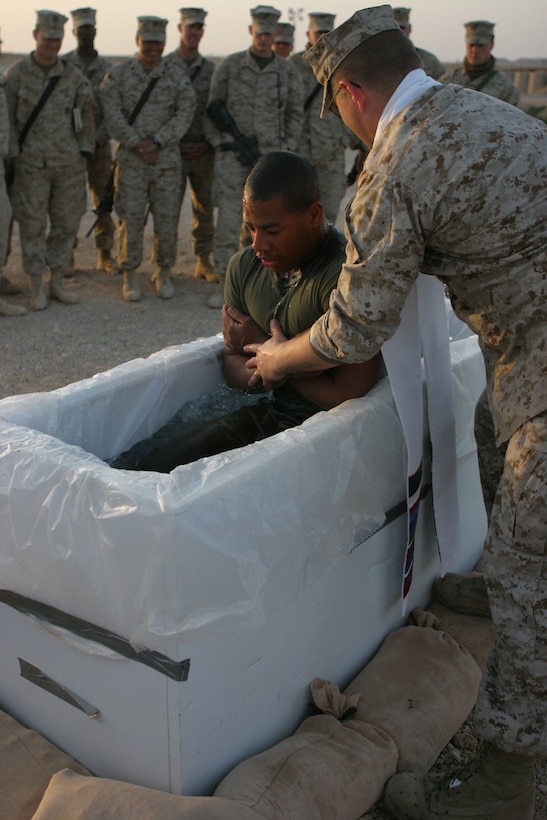 CAMP AL QA'IM, Iraq (March 27, 2005)- Pfc. Sean M. Henry, a mortar man with Company K, 3rd Battalion, 2nd Marine Regiment is baptized by Navy LT. John Anderson, the battalion chaplain here Easter Sunday. The Queens, N.Y., native joined the Corps over a year ago and this is his first deployment to Iraq. Henry, 19, a 2003 August Martin High School decided to be baptized the day before Easter and described his feelings while being baptized as feeling the purity come over him. The sunrise service was to signify the rising of the son of God as the Sun rises in the horizon. Official U.S. Marine Corps photo by Lance Cpl. Lucian Friel (RELEASED)