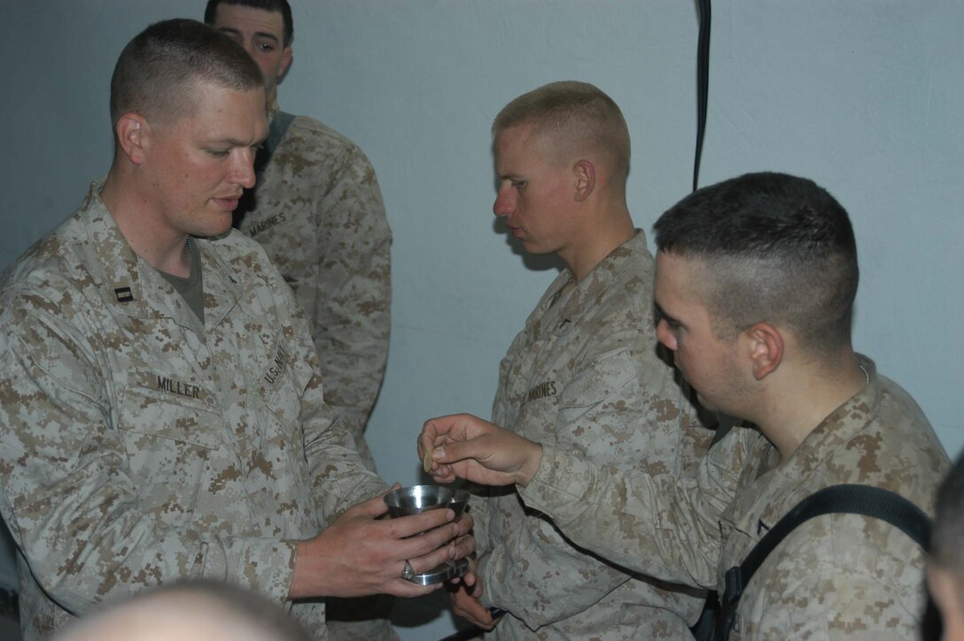 AR RAMADI, Iraq (March 27, 2005) - Nineteen-year-old Pfc. Rick R. Blakely, a rifleman with 3rd Squad, 4th Platoon, Company A, 1st Battalion, 5th Marine Regiment, takes Holly Communion from Navy Lt. Aaron T. Miller, the infantry battalion's chaplain, at the Government Center building here Easter Sunday. The 32-year-old man of God from Redlands, Calif., conducted a hasty, 15-minute Easter service for Blakely and other Company A Marines. Though the Easter celebration wasn't the same as Blakely is used to back home in Prescott, Mich., the 2004 Whittemore High School graduate said it would be one of his most memorable. Photo by Cpl. Tom Sloan