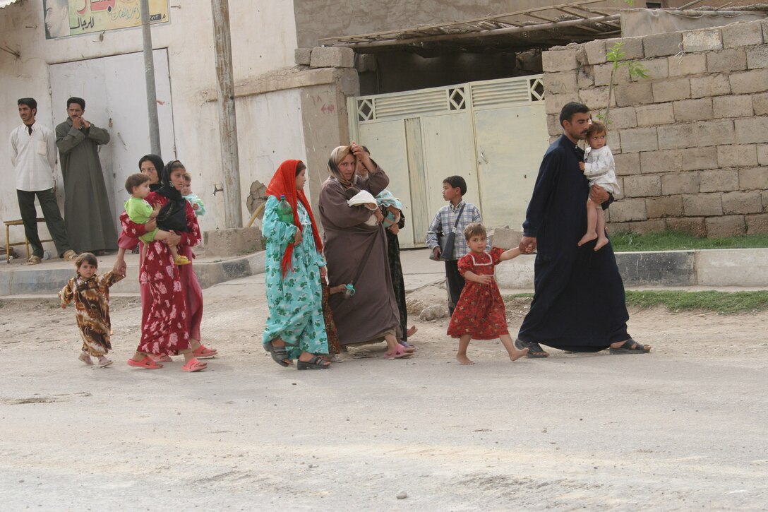 Haqlaniyah, Al Anbar, Iraq.-- A family returns to the city as the community returns to its normal activities.  Families either stayed in their homes or left to live with friends and relatives in nearby towns during the operation.  It is common for Iraqis to have many relatives living within a short distance.  The eldest man usually stays with the house to protect his family's property from trespassers and looters.     (Photo by LCpl. Marc Fencil. )