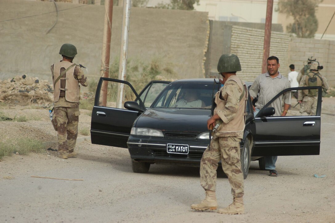AR RAMADI Iraq (June 27, 2005) - Two members of the Iraqi Security Forces stop a car and prepare to search it during a mission in the city here June 26 with 1st Battalion, 5th Marine Regiment's Company C Marines. Marines with the infantry battalion's Combined Action Platoon in Company B train new members of the ISF at their base, Camp Ali. After 12 days of intense training, the ISF conduct missions alongside other elements of the infantry battalion to further hone their military skills. Photo by: Cpl. Tom Sloan