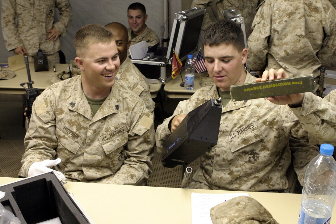 CAMP FALLUJAH, Iraq - Sgt. Dwain Midthun, left, and a fellow Marine from 1st Battalion, 6th Marine Regiment, test out the EVD-3000's capabilities during a class on this new system here June 27.  1st Battalion, 6th Marine Regiment personnel will receive these handheld explosive detecting devices to assist them in searching vehicles and personnel entering Fallujah.