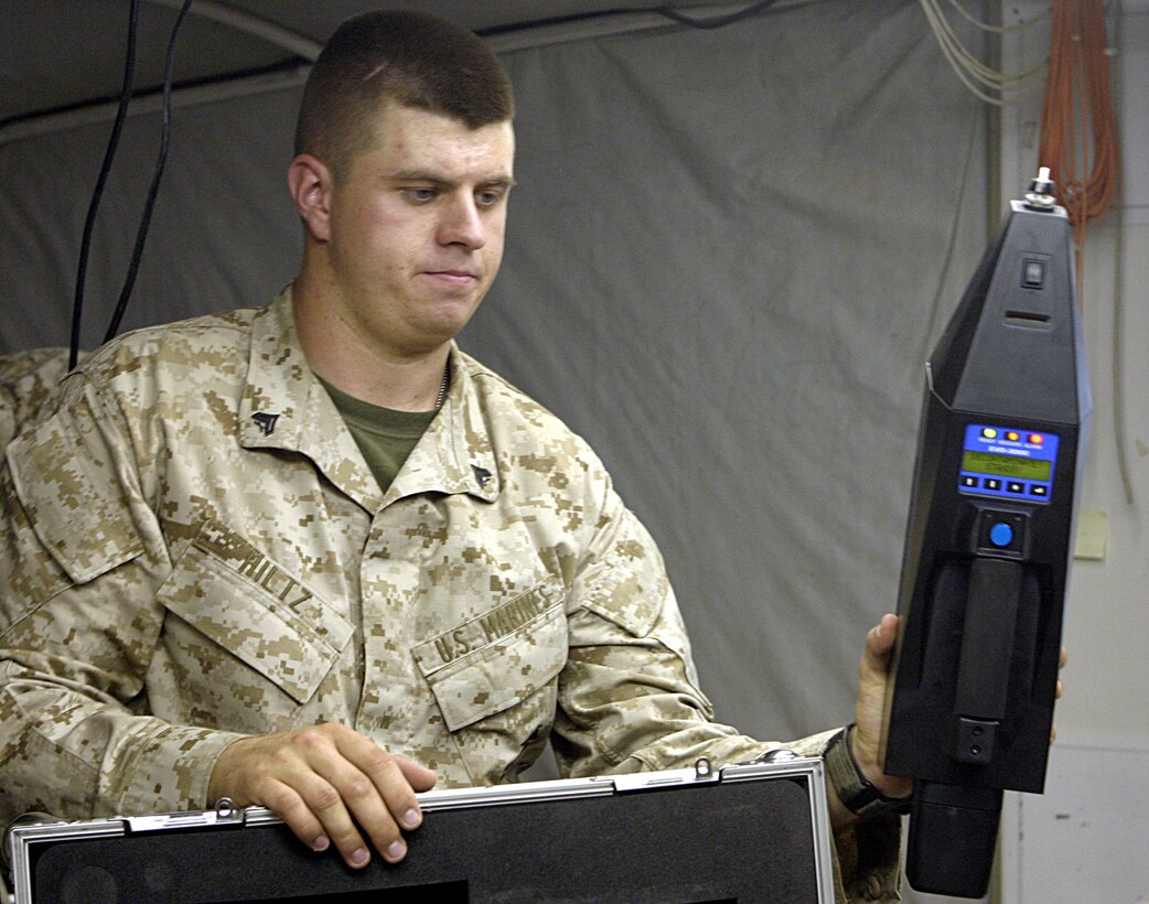 CAMP FALLUJAH, Iraq - Cpl. Jonathan Hiltz, Nuclear, Biological, and Chemical threat specialist noncommissioned officer for Regimental Combat Team-8, instructs 1st Battalion, 6th Marine Regiment personnel on the EVD-3000.  The 21-year-old McAllen, Texas native showcased the handheld explosives detecting device to personnel who will soon use it to search vehicles and personnel entering Fallujah for explosive materials.