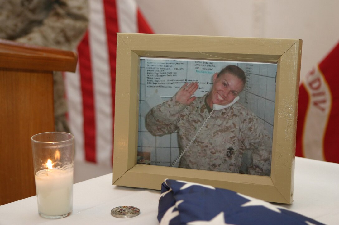 CAMP BLUE DIAMOND, AR RAMADI, Iraq - A photograph, a folded flag and a candle are presented as a memorial, June 27, to Cpl. Holly Charette, a 21-year-old from Cranston, R.I., who deployed here earlier this year with the 2nd Marine Division for Operation Iraqi Freedom.  Charette was killed in a suicide car-bombing when her convoy was struck just a few days earlier.  U.S. Marine Corps photo by Sgt. Stephen D'Alessio (RELEASED)