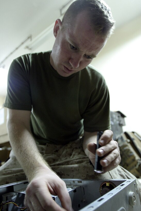 Haditha Dam, Al Anbar, Iraq (July 14, 2005)--Lance Cpl. Marco S. Lentini, 24, 3rd Battalion, 25th Marines assistant data chief and Twinsburg, Ohio native rebuilds a computer. (Official USMC Photo by Corporal Ken Melton)