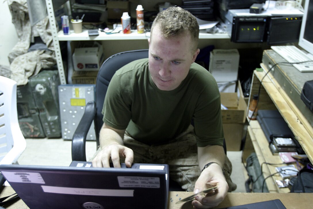 Haditha Dam, Al Anbar, Iraq (July 14, 2005)--Lance Cpl. Marco S. Lentini, 24, 3rd Battalion, 25th Marines assistant data chief and Twinsburg, Ohio native repairs a computer. (Official USMC Photo by Corporal Ken Melton)