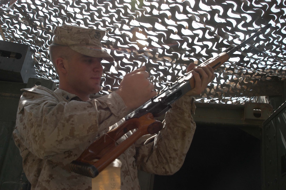 CAMP HURRICANE POINT Ar Ramadi, Iraq (July 20, 2005) - Lance Cpl. Adam J. Kircher, an armorer with Headquarters and Service Company, 1st Battalion, 5th Marine Regiment, inspects an enemy weapon that was recently seized by Marines in the city. The 22-year-old from Omaha, Neb., and six other Marines work at the armory and are responsible for keeping all the Camp Pendleton, Calif., -based infantry battalion's warriors armed with fully operational weapons so they can complete their mission on the urban battlefield. Photo by: Cpl. Tom Sloan