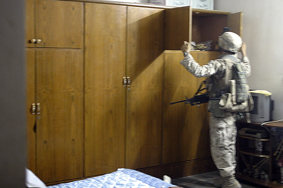 SAQLAWIYAH, Iraq - A Marine with 2nd Squad, 4th Platoon, Company A, 1st Battalion, 6th Marine Regiment searches inside for weapons inside a home here July 27 during Operation Hard Knock.  Company A Marines searched dozens of houses throughout the small township outside Fallujah, looking for weapons, explosives and insurgent activity while gathering census data on the populace there.  The Marines apprehended one suspected insurgent supporter.