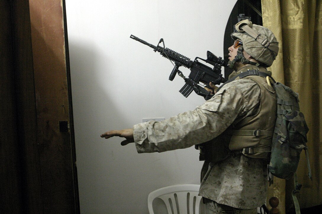 SAQLAWIYAH, Iraq - Sgt. Daniel Kachmar, 2nd squad leader, 4th Platoon, Company A, 1st Battalion, 6th Marine Regiment, searches for weapons inside a home here July 27 during Operation Hard Knock.  Company A Marines searched dozens of houses throughout the small township outside Fallujah, looking for weapons, explosives and insurgent activity while gathering census data on the populace there.  The Marines apprehended one suspected insurgent supporter.