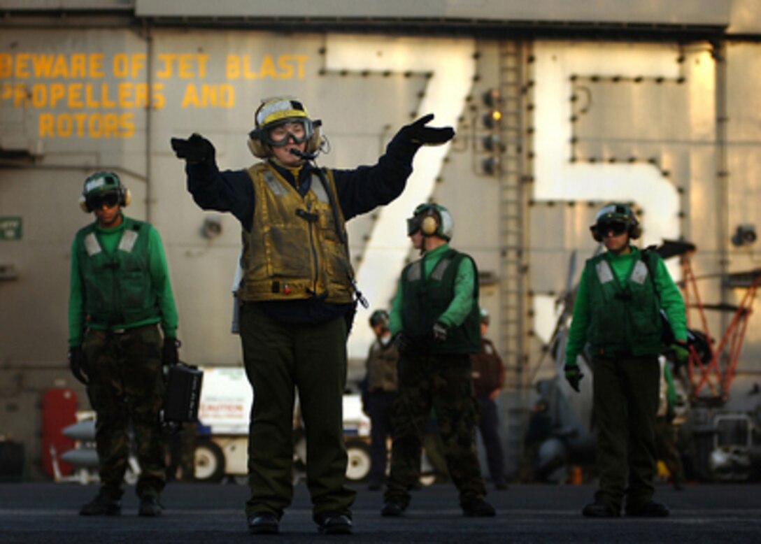 Navy Petty Officer 3rd Class Amanda Volino directs the pilot of an aircraft preparing to launch from the flight deck of the USS Harry S. Truman (CVN 75) on Jan. 21, 2005. Truman and embarked Carrier Air Wing 3 are conducting close air support, intelligence, surveillance, and reconnaissance missions over the Persian Gulf region in support of the war on terror. Volino is a Navy Aviation Boatswain's Mate (Handler) onboard the Nimitz-class aircraft carrier. 