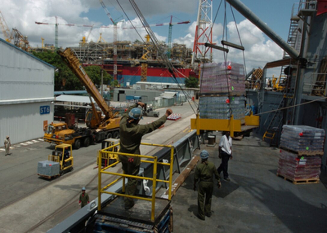 Sailors from Supply Support Battalion 2 assist civilian mariners in loading the USNS Concord (T-AFS 5) with supplies in Singapore on Jan. 22, 2005. Concord is being loaded with humanitarian aid supplies for the South East Asia tsunami victims as well as subsistence items, ship store items, and repair parts for the USS Abraham Lincoln (CVN 72) Battle Group, which is deployed in support of Operation Unified Assistance. The Supply Support Battalion sailors are deployed from the Naval Reserve Center Bronx, N.Y. 