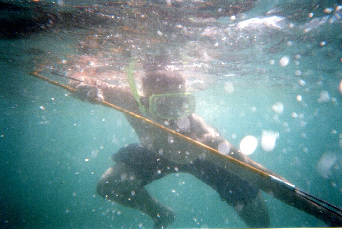 Lance Cpl. Aaron D. Banks, traffic management specialist, Headquarters Battalion, Marine Corps Base Hawaii, Kaneohe Bay, pulls back on his spear before releasing it to spear a fish in the waters at North Beach aboard Marine Corps Base Hawaii, Kaneohe Bay.