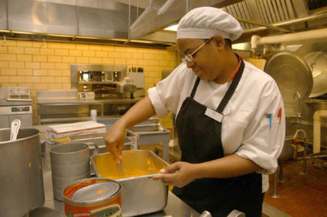 Synthia M. Willson, Mess Hall special bar cook, stirs a batch of cheese for the station s mess hall potato bar. Willson said she feels it is her job to make the food to the best of her ability to keep their patrons pleased. Such dedication to excellence among dining facility personnel has paid off. The station dining facility won its third consecutive Maj. Gen. W.P.T. Hill Memorial Award Dec. 20.