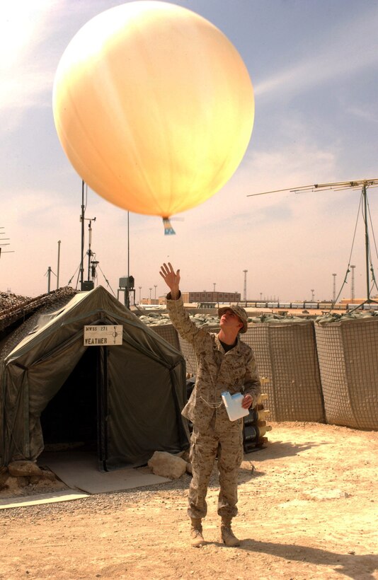 Cpl. Todd D. Patrick, 22, from Medina, Ohio, releases a weather balloon aboard Al Qaim, Iraq.  The balloon's transmitter will send data back to observers.  This information relates to the upper atmosphere, and makes it possible to forecast different weather fronts that may affect the region.  The data is important to the pilots who use this location as a base of operations.  These Marines are part of Marine Wing Support Squadron 271 from Cherry Point, N.C.  This forward operating base acts as a forward arming refueling point for aircraft in the region.