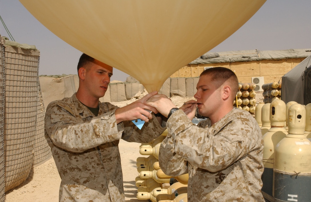 Cpl. Todd D. Patrick, 22, from Median, Ohio, and Lance Cpl. Allan J. Bourquin, 21, from Brocton, N.Y. inflate a weather balloon aboard Al Qaim, Iraq.  The balloon will be released into the atmosphere, sending data back to observers.  This information relates to the upper atmosphere, and makes it possible to forecast different weather fronts that may affect the region.  This information is important to the pilots who use this location as a base of operations.  These Marines are part of Marine Wing Support Squadron 271 from Cherry Point, N.C.  This forward operating base acts as a forward arming refueling point for aircraft in the region.