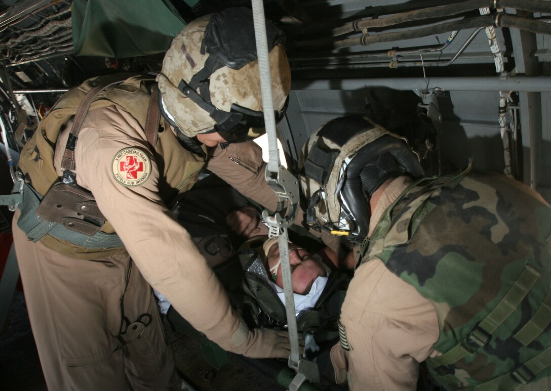 Conversing with the pilots, Lance Cpl. Isaac Avendano, a crew chief with Marine Medium Helicopter Squadron 161 and Ventura, Calif., native, helps land a CH-46 Sea Knight safely at Ramadi, Iraq. Minutes after landing, they picked up a U.S. service member who had been wounded by an improvised explosive device and was in urgent need of medical attention.