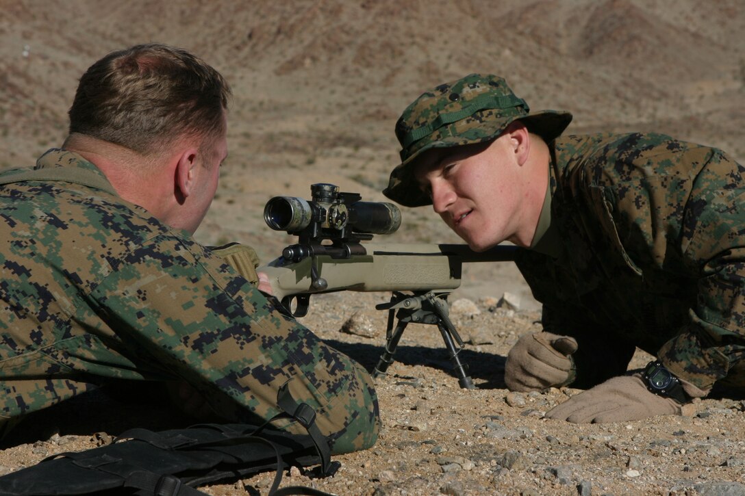 050115-M-4224F-003 MARINE CORPS AIR GROUND COMBAT TRAINING CENTER TWENTY-NINE PALMS, Calif.- Cpl. Aaron W. Smith, a native of Suffolk, Va., helps a fellow Marine prepare his M40 A3 sniper rifle during sustainment training to prepare the Marines for deployment to Iraq. Smith, a scout sniper with Weapons Company, 3rd Battalion, 2d Marine Regiment graduated from Northern High School in Durham, N.C., and is making his second deployment to Iraq. U.S. Marine Corps photo by Lance Cpl. Lucian Friel (RELEASED)