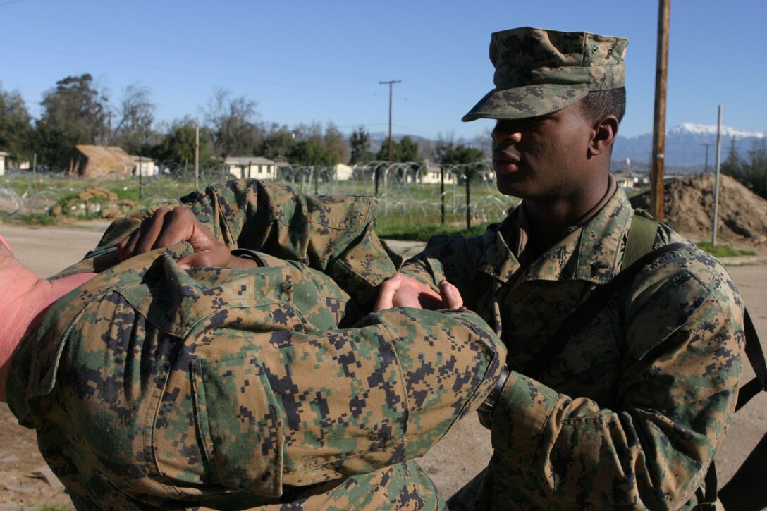 050119-M-4224F-001 MARCH AFB MORENO VALLEY, Calif.- Pfc. Jarius Hardnett, 19, a radio operator with 3rd Battalion, 2d Marine Regiment detains a fellow Marine during security and stabilzations operations Jan. 19. The training was the last opportunity for the 2003 McNair High School graduate to prepare for deployment to Iraq. U.S. Marine Corps photo by Lance Cpl. Lucian Friel (RELEASED)