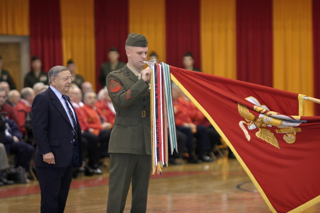 050128-M-2607O-002 MARINE CORPS BASE CAMP LEJEUNE, N.C. (January 28, 2005) -- A Marine and a member of the 2nd Marine Division Association rededicate one of the division's battle streamers during their 64th birthday celebration.  Many members of the association attended the ceremony and a meet and greet get together, the evening prior.  (Official U.S. Marine Corps photo by Pfc. Christopher J. Ohmen)