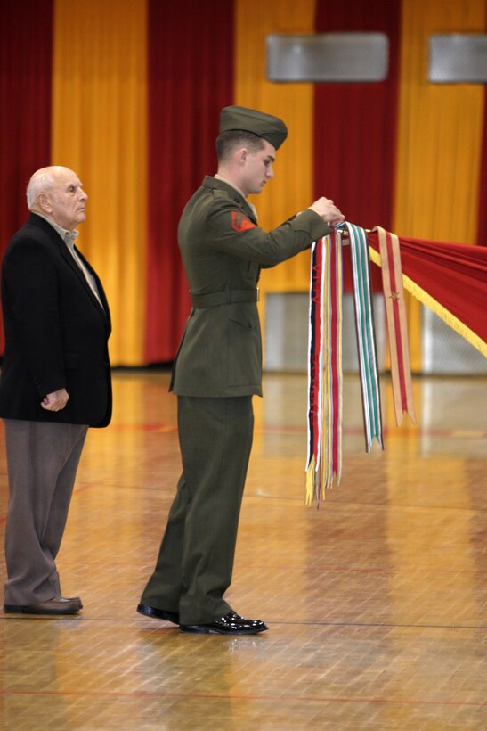 050128-M-2607O-003 MARINE CORPS BASE CAMP LEJEUNE, N.C. (January 28, 2005) -- A Marine and a member of the 2nd Marine Division Association rededicate one of the division's battle streamers during their 64th birthday celebration.  Many members of the association attended the ceremony and a meet and greet get together, the evening prior.  (Official U.S. Marine Corps photo by Pfc. Christopher J. Ohmen)